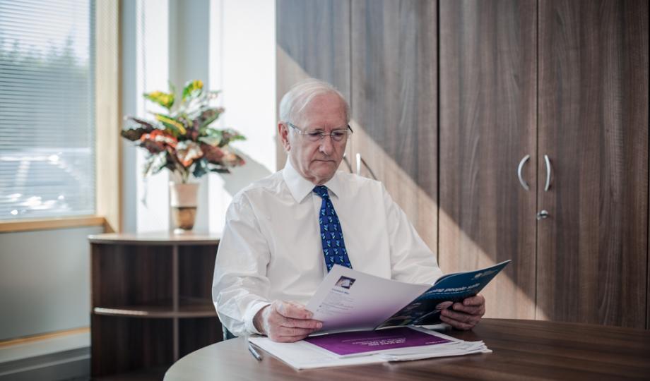 Dr Alan Billings reading a publication